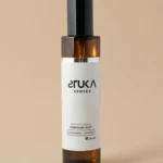 Elegante botella de spray aromatizante sobre suave tela de cachemira y madera STUKA SENSES